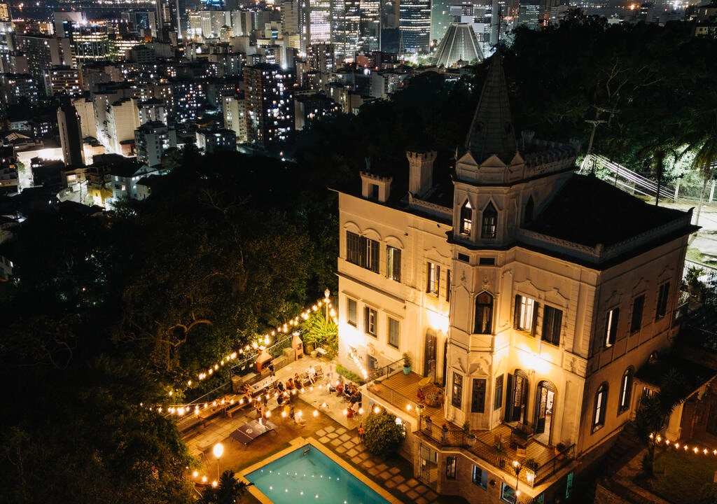 The illuminated castle and pool, with Rio by night behind